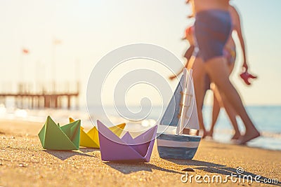 Paper boats, wood boat and walking people at the beach Stock Photo