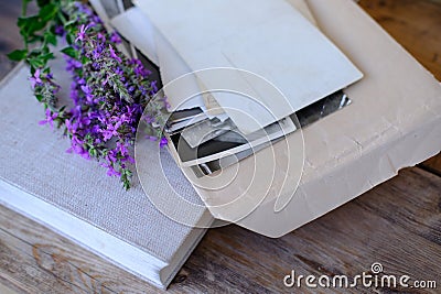 paper book, old photographs, home archive, letter on old wooden table, touching objects of nostalgia, past love, bunch of wild Stock Photo