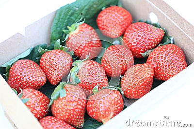 Paper box with red strawberry for sale in the fruit and vegetable market. Close up. Tasty seasonal fruit, fresh and heathy. Stock Photo