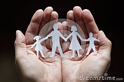 Paper chain family protected in cupped hands Stock Photo