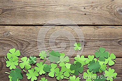 Paper clover leaves on the old wooden background. Lucky shamrock Stock Photo