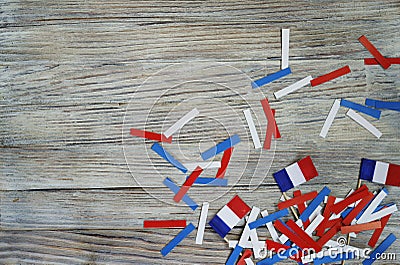 Paper confetti of the national colors of France, white-blue-red on a white wooden background with flags, concept Bastille day, Jul Stock Photo