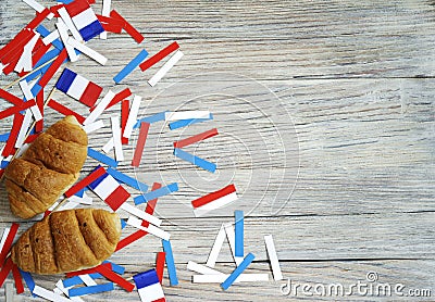 Paper confetti of national colors of France, white-blue-red on a white wooden background with flags and croissants, concept Bastil Stock Photo