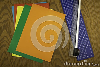 Paper cutter and color origami paper on a wooden table Stock Photo