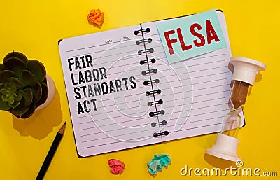 Paper with Fair Labor Standarts Act FLSA on a table with pen, charts and magnifier Stock Photo