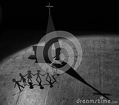 Paper figures of people going to a church with shadow from spotlight Stock Photo