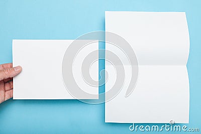 Paper flyer A5 mockup, man holding blank on blue background Stock Photo