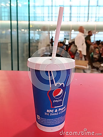 A paper glass of Pepsi brand soft drink in a KFC outlet Editorial Stock Photo