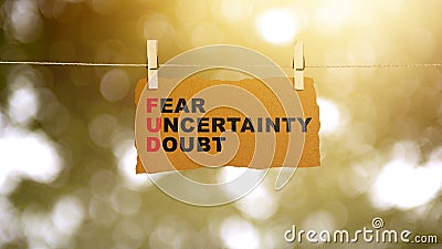 Paper hanging on the rope with 'Fear Uncertainty Doubt' text Stock Photo