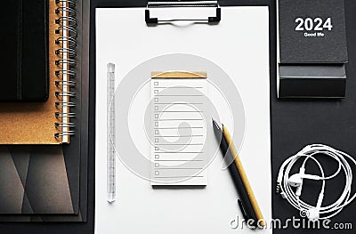 Paper holder next to folders, notepads, pens, calendar and wired headphones Stock Photo