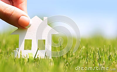 Paper house in green grass over blue sky Stock Photo