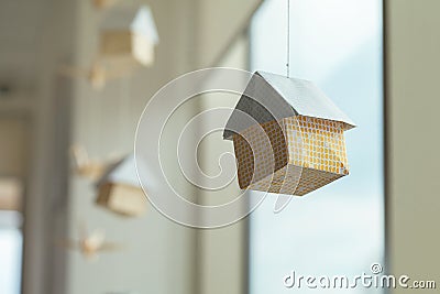 Paper house on the thread near the window. Origami Stock Photo