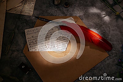 Paper letters, craft carpet, quill, inkwell and flowers lie on the table. Bright sunny day. View from above. Stock Photo