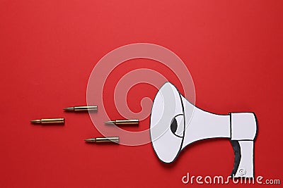Paper loudspeaker and bullets on red background, flat lay with space for text. Hybrid warfare concept Stock Photo
