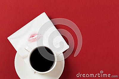 Paper napkin with a kiss and coffee cup on red background Stock Photo