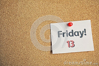 Paper note with phrase Friday! 13 pinned to cork background. Bad luck superstition Stock Photo