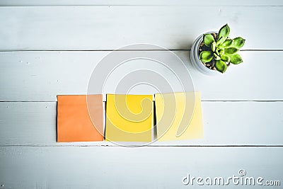 Paper note on white wood table with pot cactus/copy space. Stock Photo