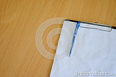 Paper and pen placed on the file on the wooden table on topview from the bottom right corner Stock Photo