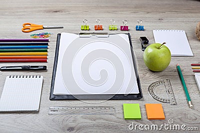 Paper, pencils, brush, green apple on wooden table Stock Photo