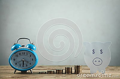 Paper piggy bank, stack of coins and alarm clock on wooden table. Time to invest your savings Stock Photo