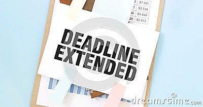 Paper plate with text take DEADLINE EXTENDED. Diagram, notepad and blue background Stock Photo