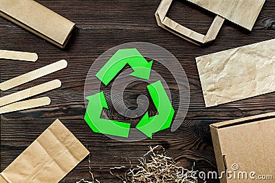 Paper recycle sign with paper and carton garbage on wooden background top view Stock Photo