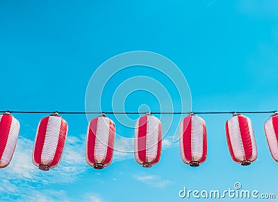 Paper red-white japanese lanterns Chochin hanging on blue sky background Stock Photo