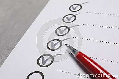 Paper sheet with checkboxes and pen on light grey table, closeup. Checklist Stock Photo