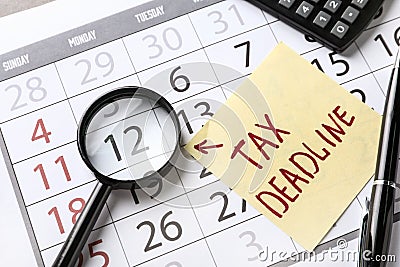 Paper sheet with text TAX DEADLINE and magnifying glass on calendar Stock Photo