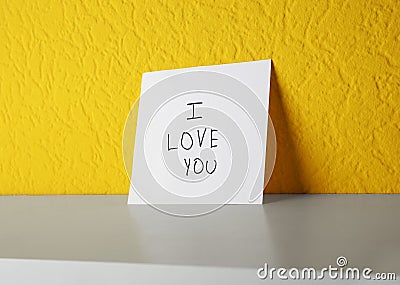 Paper with text I LOVE YOU on shelf Stock Photo