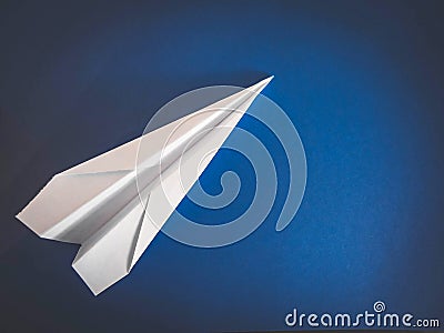 Paper white aircraft lying on a blue background Stock Photo