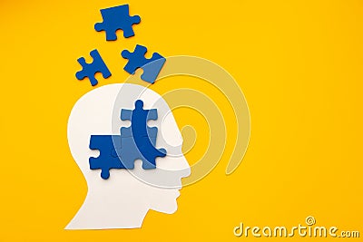 Papercut head silhouette with puzzle pieces on yellow background Stock Photo