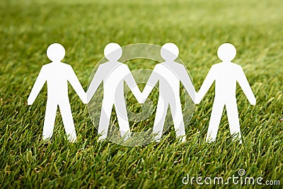 Papercut Of People Chain On Grass Stock Photo