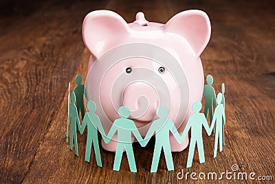 Papercut With Piggybank On Wooden Desk Stock Photo