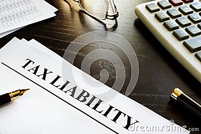 Papers with title tax liability on a desk. Stock Photo