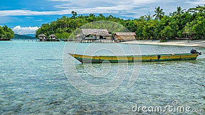 Papua Local Boat, Beautiful Blue Lagoone near Kordiris Homestay, Small Green Island and Homespay in Background, Gam Stock Photo