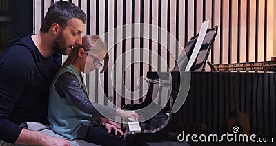 Papà insegna pianoforte a sua figlia Piccola ragazza che impara il pianoforte a vista domestica Classe di pianoforte a casa Istru video d archivio Papà insegna pianoforte a sua figlia Piccola ragazza che impara il pianoforte a vista domestica Classe di pianoforte a casa Istru video d archivio