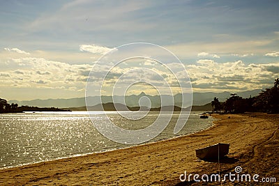 Wild Empty Tropical beach, yellow sand, sunlight reflections taken in landscape. Praia pintor Castagneto Stock Photo