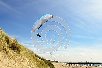 Para gliding above the dunes and coastline Stock Photo