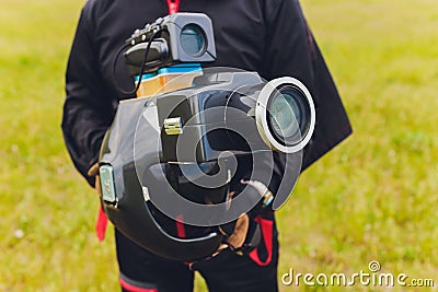 Parachute helmet with an installed DSLR camera in the hands of a skydiver, cameraman and air photographer, close-up Stock Photo