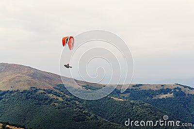 parachute skydiver flying in clouds at mountains, travel adventure concept, space for text Stock Photo
