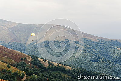 Parachute skydiver flying in clouds at top of mountains with ama Stock Photo