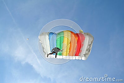 Parachuter, skydiver jumping and skydiving with colorful parachute in rainbow colours on parachuting cup, extreme sport Editorial Stock Photo