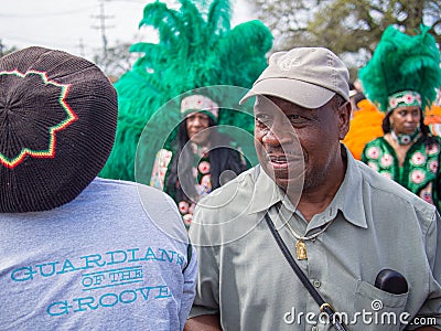 Paradegoer, Mardi Gras Indians and Guardians of the Groove at Uptown Super Sunday parade Editorial Stock Photo