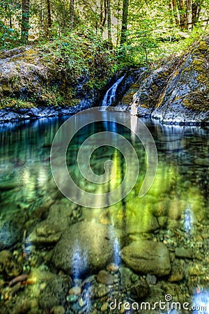 Paradise creek swimming hole with water and a short waterfall in the center on the lower Rogue River Stock Photo