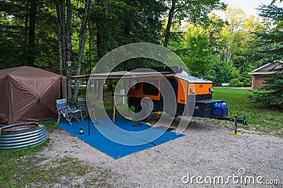 Paradise, MI - August 9, 2023: An orange and black Hiker teardrop camper parked in at a State Park Editorial Stock Photo