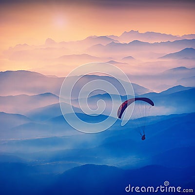 Paraglide silhouette in a light of sunrise. Vintage colors Stock Photo