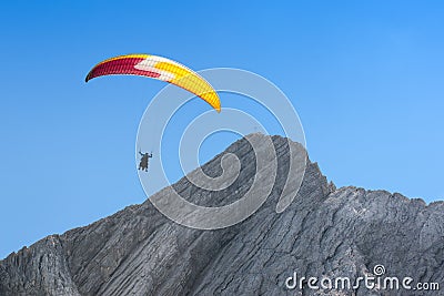 Paraglider free soaring in cloudless sky over dolomites Alpine m Stock Photo