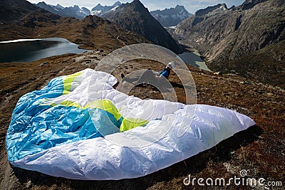 Paraglider Pilot sits with his paraglider on the ground and recovers after ground handling Stock Photo