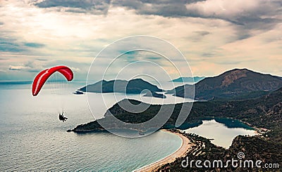 Paraglider tandem flying over the Oludeniz Beach and bay at idyllic atmosphere. Oludeniz, Fethiye, Turkey. Lycian way. Stock Photo